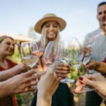 Photo of a couple of friends in a winery, tasting and trying different types of wines