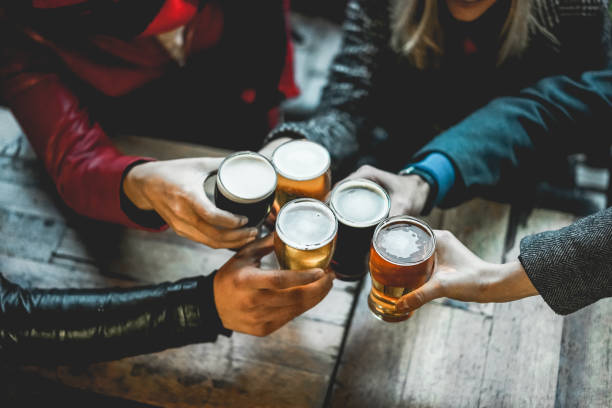 Young group of people having fun cheering with beer